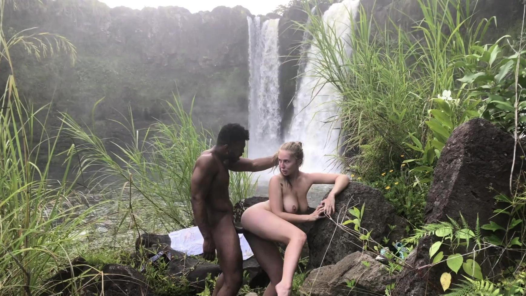 Nena de tetas grandes chupando una gran polla negra al aire libre y pateando junto a una cascada hawaiana